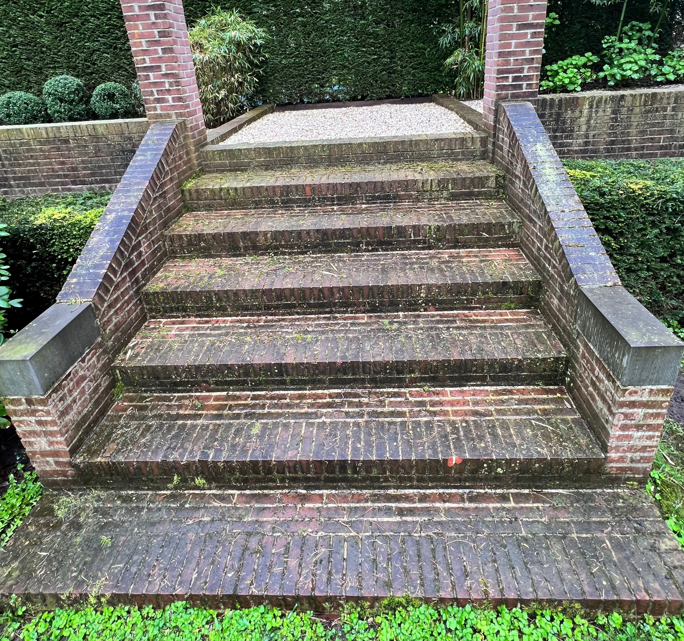 A person sitting on bricks wearing untied boots.